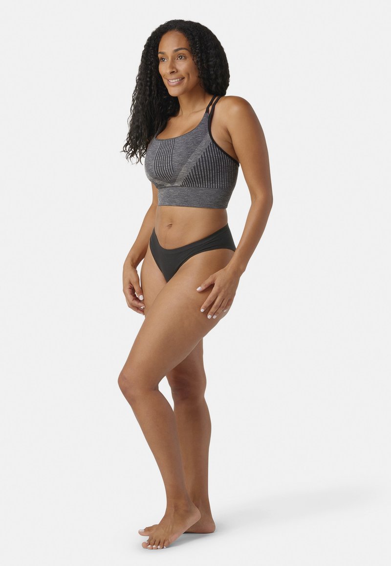Reggiseno sportivo atletico nero con motivo grigio testurizzato e spalline doppie, abbinato a uno slip bikini nero a vita alta. Tessuto liscio, design aderente.
