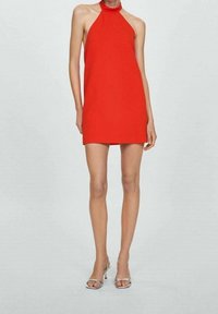 Rode halterjurk met een rechte snit, minimalistisch design en een zachte textuur. Gecombineerd met glanzende zilveren hoge hakken Sandalen.