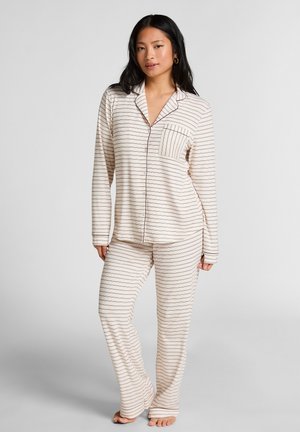Roomkleurige pyjamastel met strepen, bestaande uit een lange mouw blouse met knopen en een borstzakje, en bijpassende broek met een losse pasvorm.