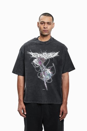 Juoda didelio dydžio trumpomis rankovėmis marškinėliai, kuriuose pavaizduota grafika su rože ir grandinėmis, esanti ant nusidėvėjusio audinio tekstūros.