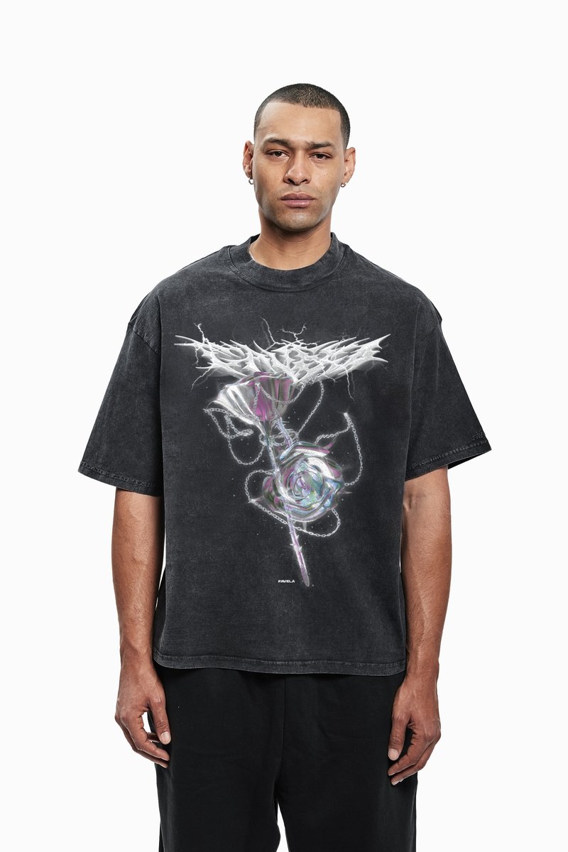 Sort oversized T-shirt med korte ærmer, der har et grafisk design af en rose med kæde-detaljer, sat op imod en slidt stofstruktur.