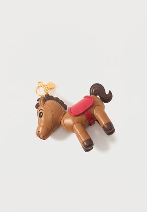 Breloc din piele maro în formă de cal, cu șa roșie, coamă și coadă închise la culoare și un inel de chei auriu pe un fundal alb.