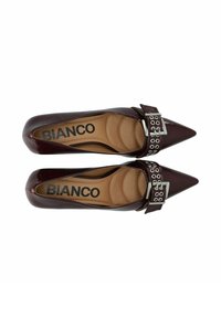 Scarpe in vernice bordeaux con punta appuntita e cinturino con fibbia, caratterizzate da hardware decorativo in argento e soletta imbottita per il comfort.