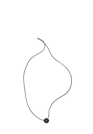 Black cord necklace with a single round black bead pendant, featuring a smooth texture and simple design. Adjustable length with no additional accents.