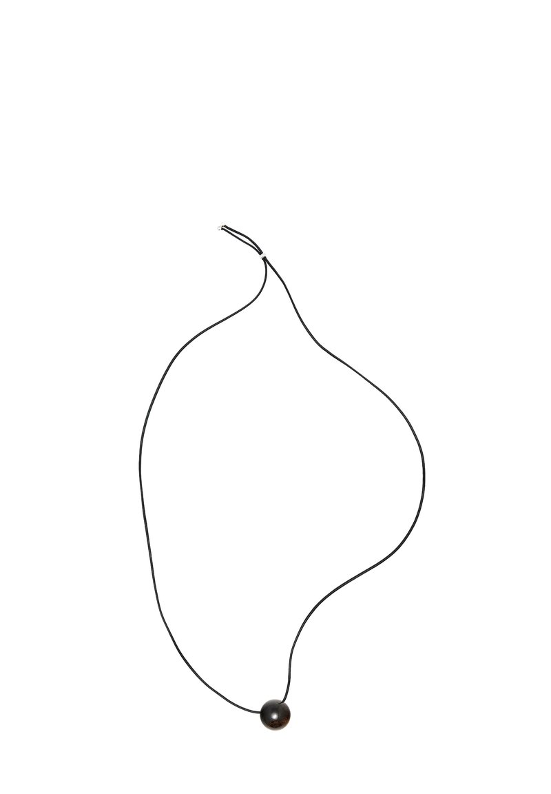 Collana con cordoncino nero e pendente singolo con perla rotonda scura, caratterizzata da una texture liscia e un design minimalista.