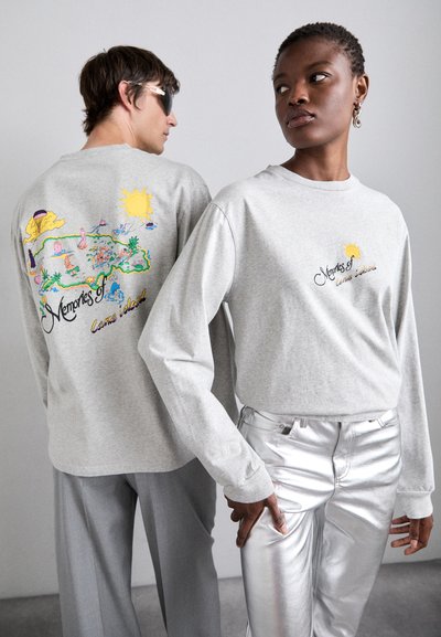 Gray long-sleeve t-shirts feature colorful graphic prints on the back and front, paired with shiny silver pants. Texture is soft and smooth.