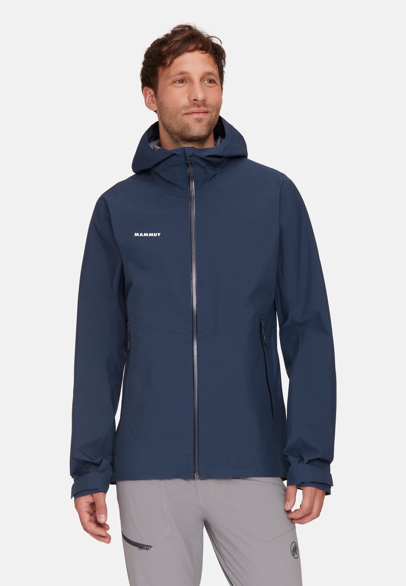 Giacca impermeabile blu navale con cappuccio, chiusura zip frontale e due tasche laterali. Caratterizzata da una texture liscia e logo bianco sul petto.