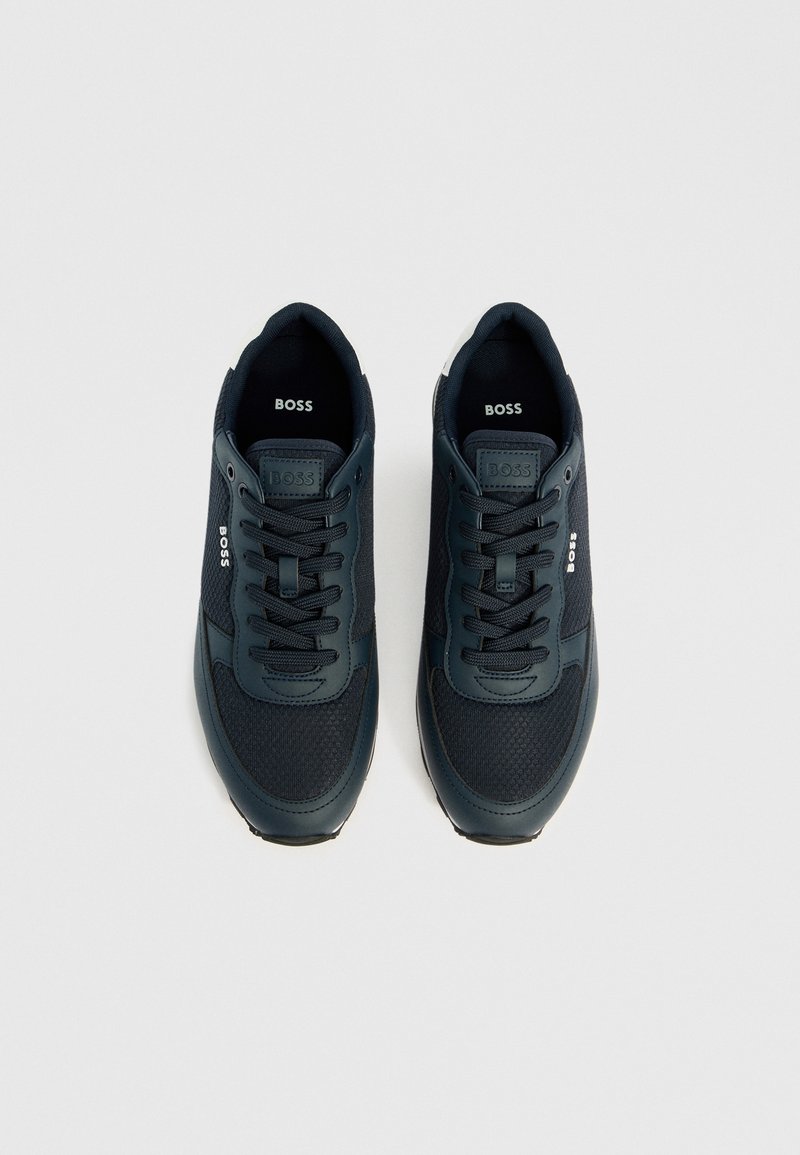 Baskets bleu marine en maille et en matériau synthétique, avec un bout arrondi, un col rembourré, des accents blancs et un logo sur la languette.