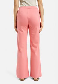 Pink wide-leg pants featuring a smooth texture, elastic waistband, and back pockets. Visible stitching along the back seam.