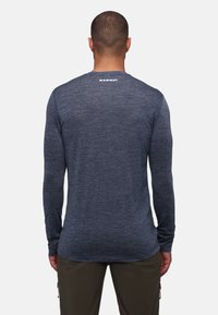 Langarmshirt in Marineblau, aus einem strukturierten Stoff gefertigt. Verfügt über einen runden Halsausschnitt und ein Logo im oberen Rückenbereich.