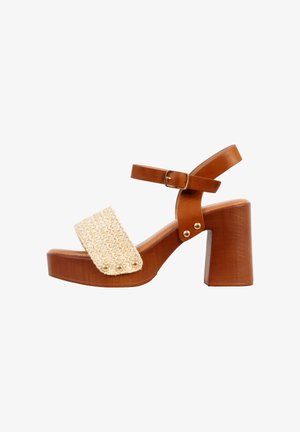 Bruine sandalen met blokhak, voorste band van beige gevlochten materiaal, enkelband met gesp en gouden klinknagelaccenten.