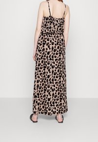 Maxiklänning med leopardtryck i beige och svart, tillverkad i lätt tyg, med tunna band och elastisk midja för bra passform.