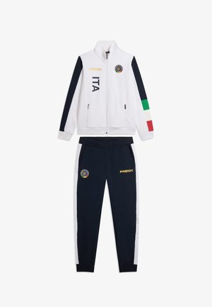 Survêtement blanc et marine avec des bandes aux couleurs du drapeau italien sur les manches, texte ITA, et logos de la marque Freddy sur la veste et le pantalon.