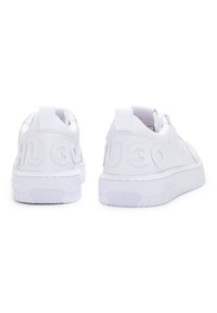 Baskets en cuir blanc avec une finition lisse, semelle en caoutchouc texturé et logo "HUGO" en relief à l'arrière. Cheville rembourrée et languette de tirage.