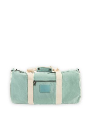 Bolsa de lona rectangular color verde claro con correas beige, bolsillo frontal con cremallera y asa superior asegurada con botones de presión.