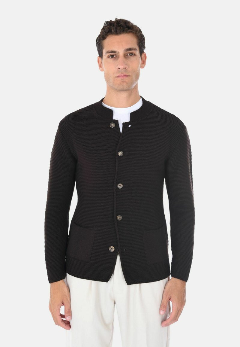 Cardigan nero lavorato a maglia con collo tondo, bottoni beige e due tasche frontali. La texture è a costine; si adatta vicino al corpo.