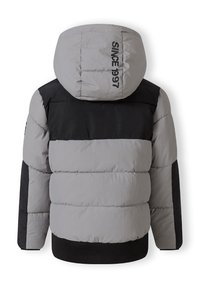 Siltināta jaka ar pelēku ķermeni, melniem pleciem un kapuci. Iespējami riboti piedurkņu un hem, uz aizmugures drukāts "KOPŠ 1997".