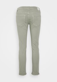 Jeans ajustados en algodón de un suave verde oliva, con dos bolsillos traseros que presentan un sutil patrón de costura diagonal y dobladillos en el final.