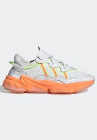 Kevyt lenkkarikenkä, jossa on valkoinen verkkoyläosa, neonvihreät ja oranssit yksityiskohdat sekä kuvioitu oranssi kumipohja. Ominaisuuksiin kuuluu joustava muotoilu.