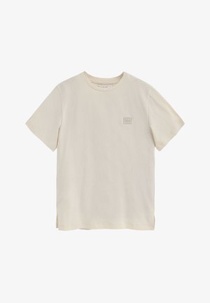 T-shirt à col rond à manches courtes en blanc cassé, avec un tissu texturé, un petit patch logo en forme de carré sur la poitrine et des fentes sur les côtés.