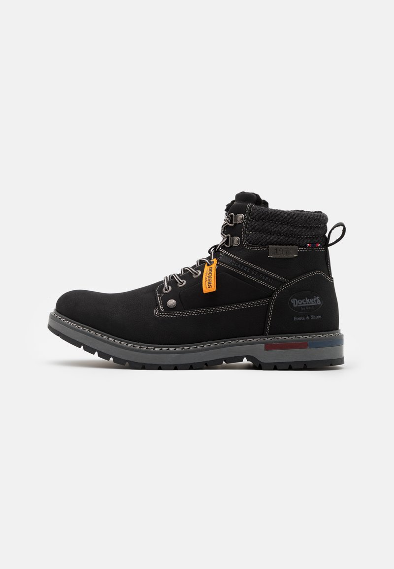 Sorte ankelstøvler med en tekstureret stofoverdel og grå gummisål. Har metaløjer, en strikket krave og et orange mærke.