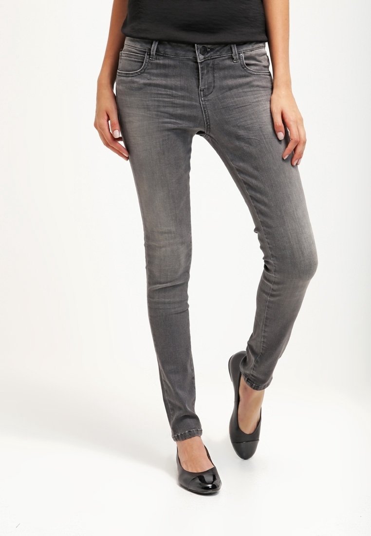 Jeans skinny de denim gris con un acabado ligeramente desgastado, diseño de cinco bolsillos y cintura de tiro medio, combinados con bailarinas negras.