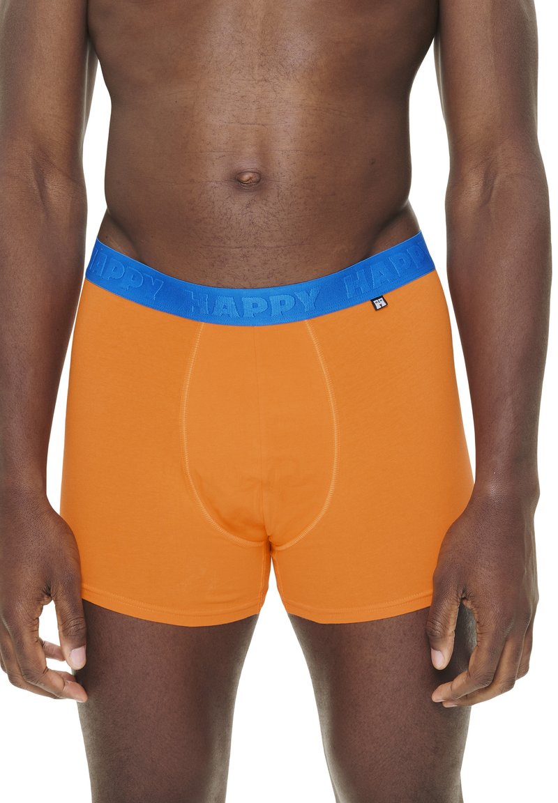 Orange boxer briefs with a blue elastic waistband featuring the word "HAPPY." Smooth fabric, fitted design, and a standard fly contour.