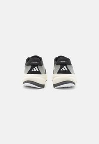 Black and grey athletic shoes with mesh upper, padded heel collar, and white sole. Features three white stripes on outer heel.