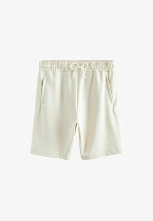 Shorts couleur crème en tissu doux, dotés d'une taille élastique avec cordon de serrage et de deux poches latérales.