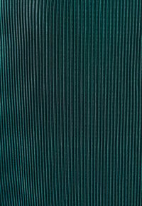 Tissu teal avec des nervures verticales, présentant un léger éclat. La texture est lisse avec de fins fils réfléchissants tissés tout au long.