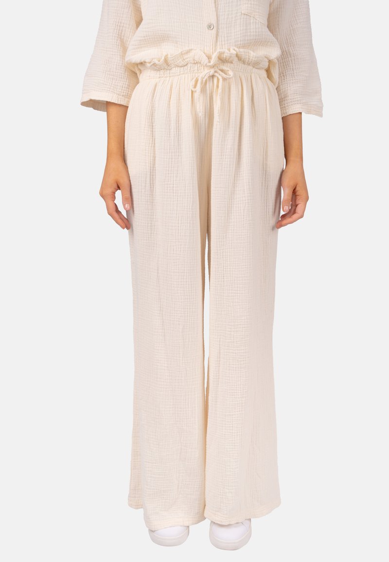 Leichte, cremefarbene weit geschnittene Hosen aus strukturiertem Stoff mit elastischem Bund und Kordelzug, die eine lockere Passform bieten.