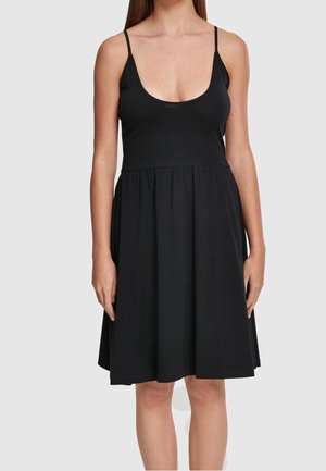 Vestido negro sin mangas con un escote redondeado profundo y una falda acampanada, hecho de una tela suave y ligera.