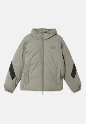 Casaco acolchoado em verde oliva com capuz, fecho de correr, dois bolsos frontais, detalhes em preto nas mangas e um logótipo no peito.