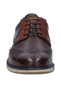 Braune Leder-Schnürschuhe mit einem Akzent aus hellbraunem Leder, Brogue-Details, runder Zehenform und einer kontrastierenden weißen Sohle.