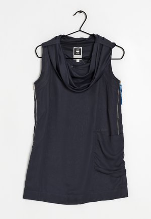 Bezrękawnik w kolorze granatowym z dekoltem w cowl, wykonany z lekkiego materiału. Posiada boczny zamek oraz dużą kieszeń z przodu.