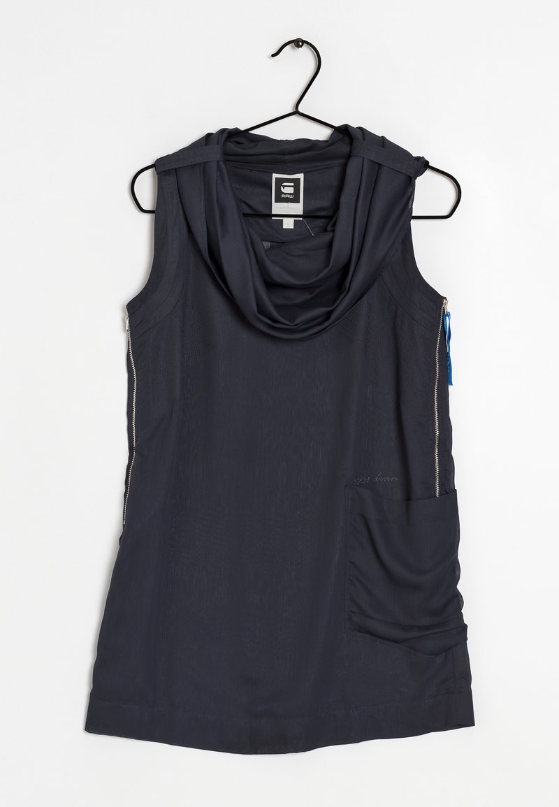 Top bez rukávů v námořnické modři s cowl výstřihem, vyrobený z lehkého materiálu. Obsahuje boční zip a velkou kapsu na přední straně.