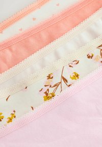 Vier Schichten Stoff: pastellrosa, korallenrot, creme mit floralem Muster und ein einfarbiges hellrosa, alle mit gewellten Kanten.
