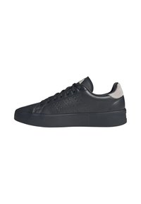 Baskets basses en cuir noir avec des détails perforés, bout rond, semelle en caoutchouc plate et accent en daim gris au niveau du talon. Lacets et logo sur la languette.