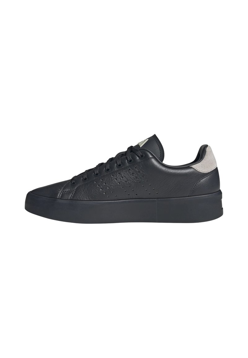 Baskets basses en cuir noir avec des détails perforés, bout rond, semelle en caoutchouc plate et accent en daim gris au niveau du talon. Lacets et logo sur la languette.