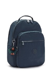 Marinblå ryggsäck med två fack med blixtlås, texturerat material, rund logotyp och en grön apa-nyckelring fäst vid.