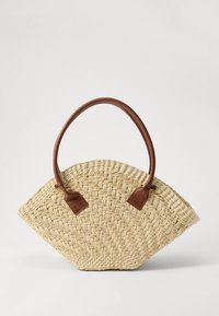 Πλεγμένη τσάντα από άχυρο σε σχήμα βεντάλιας, με καφέ χειρολαβή από ψεύτικο δέρμα. Υφή σε μπεζ χρώμα με φυσικό σχέδιο, μινιμαλιστικός σχεδιασμός.