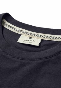Tricou din bumbac bleumarin cu guler rotund, având un finisaj texturat de crem cu un model țesut și o etichetă coasă în interior.