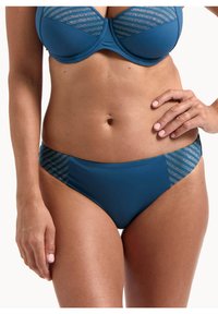 Niebieski zestaw bikini z wzorzystym topem w srebrne paski i jednolitym dołem z kontrastowymi paskami po bokach. Gładka tekstura materiału.
