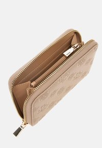 Beige ritsportemonnee met reliëfpatroon, gouden hardware, twee compartimenten en een gladde textuur. Ritsen en het merketiket zijn zichtbaar.