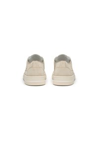 Sneaker beige in suede con una superficie liscia, forma arrotondata e suole in gomma, caratterizzati da un design minimalista e senza pattern visibili.