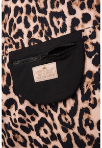Leopardenmusterstoff mit schwarzen Akzenten; verfügt über eine Reißverschlusstasche mit einem beigen Etikett, auf dem steht: "Manchmal musst du einfach dein eigenes Sonnenlicht erschaffen."