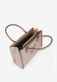 Bolso de mano beige con acentos negros, superficie texturizada, dos asas y cierre de cremallera. Bolsillos interiores para organización.