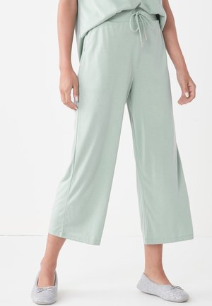 Pantalons de loisirs vert clair avec cordon de serrage, fabriqués en tissu doux et au style décontracté. Comprend des poches latérales et des jambes larges et raccourcies.