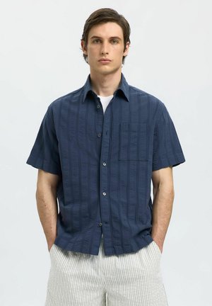Korte mouw shirt in donker marineblauw, met een gestructureerd gestreept patroon, voorzak en knoopsluiting. Lichtgewicht materiaal gecombineerd met gestreepte broek.