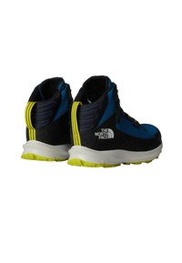 Plave i crne planinarske čizme s teksturiranim gornjim dijelom, žutim naglascima i bijelim logotipom. Imaju jastučićasto potplat i vezanje na vezice.